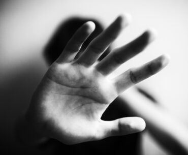 Person with hand up defending themself