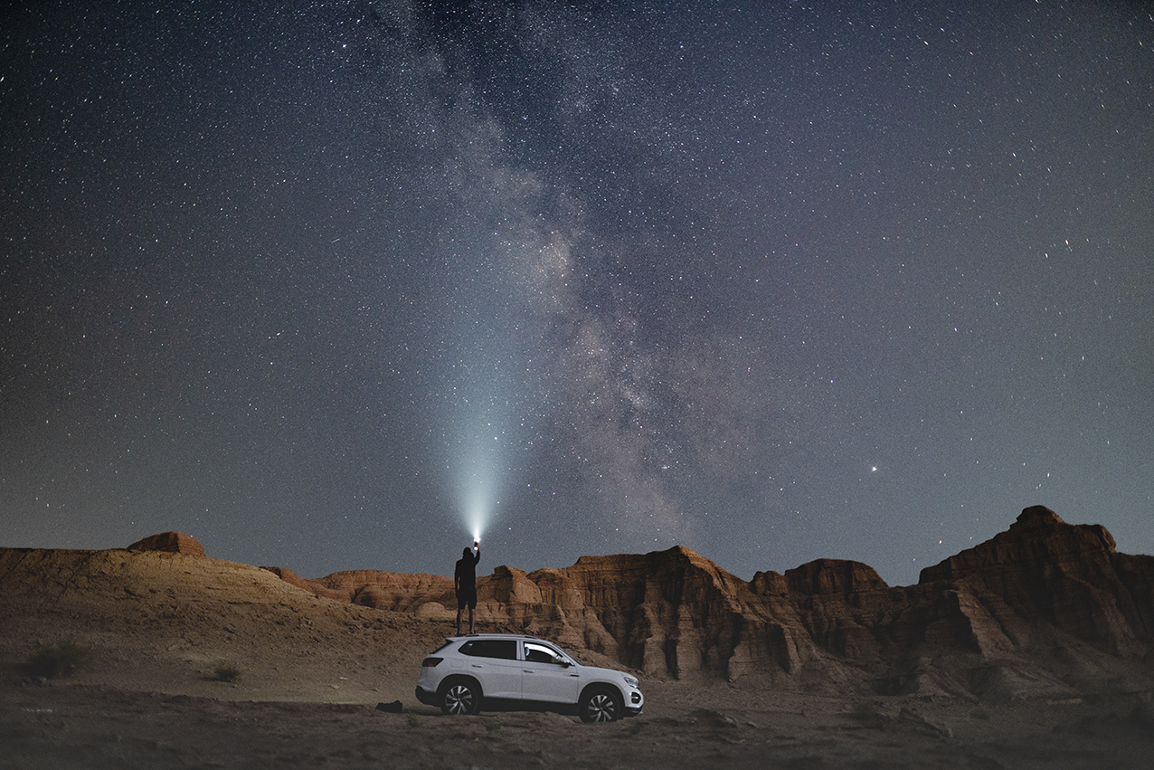 Image of SUV in desert with night sky