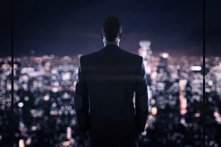 Businessman looking at the the city at night