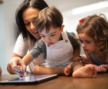 Mother with young children using an iPad