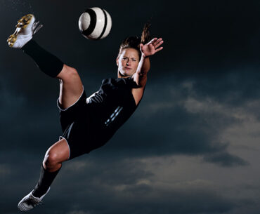 Woman rugby player about to kick the ball